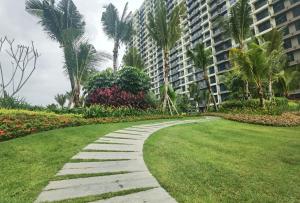 a walkway in a park with palm trees and buildings at Central Park 2 Bedrooms in Johor Bahru