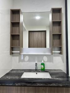 a bathroom sink with a green bottle on a counter at Central Park 2 Bedrooms in Johor Bahru