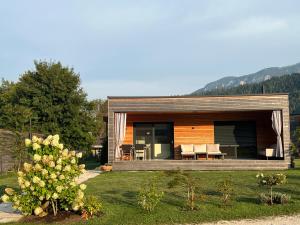 a small house with a deck and chairs in a yard at Seechalet Linsendorf in Saager