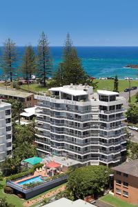 黃金海岸的住宿－Rainbow Bay Resort Holiday Apartments，享有带游泳池的大型公寓大楼的空中景致