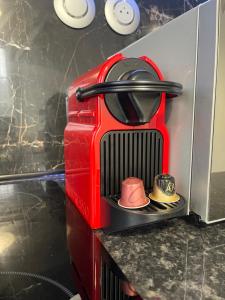 a red machine with two hats sitting on a counter at Appartement 3 pièces en face la gare de creil in Creil