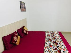 a bedroom with a bed with purple sheets and pillows at VisitorStayInn in Vrindāvan