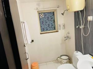 a bathroom with a sink and a toilet and a window at VisitorStayInn in Vrindāvan
