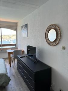 a bedroom with a desk and a mirror on the wall at Studio cabine vue mer Agde Ile des pecheurs in Cap d'Agde