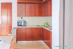 a kitchen with wooden cabinets and a microwave at Residence del mare in Ardea +17 photos