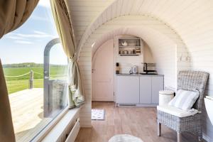 a room with an arched window and a kitchen at Seacliff Cabin in Whitekirk