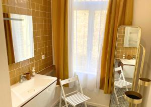un bagno con lavandino e specchio di Le Bohemian Chic - 4 chambres en hypercentre de Saint-Omer, idéal pour les groupes a Saint-Omer
