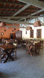 a dining room with wooden tables and chairs at Pousada Atelier Aly da Costa in Iguape