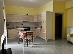 a kitchen with a table and chairs in a room at Spazioso appartamento - Casa Fe in Rossano Stazione