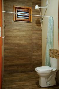 a bathroom with a toilet and a window at Casa de Serra Vila Viçosa in Viçosa do Ceará