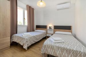 a bedroom with two beds and a window at Apartamentos Entrepuentes in Valderrobres +3 photos
