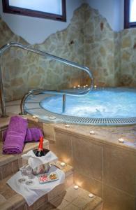 a hot tub with a table and a bottle of wine at Hotel Rosaleda Don Pedro in Úbeda