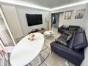 a living room with a couch and a table at Appartement chaleureux avec balcon - Champigny in Champigny-sur-Marne