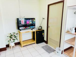 a room with a television and a desk with a computer at KLApartment in Ban Bang Chak