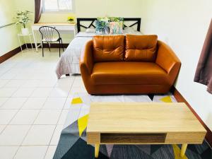 a living room with a couch and a bed at KLApartment in Ban Bang Chak