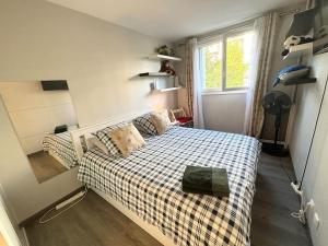 a bedroom with a bed with a checkered blanket at Appartement confort avec balcon - Champigny in Champigny-sur-Marne