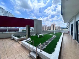 ein Balkon mit Treppe und Gras an einem Gebäude in der Unterkunft Private Cinema and Jacuzzi at Pertama Residency in Kuala Lumpur
