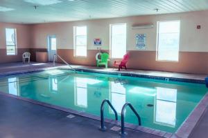 a large swimming pool with two chairs in a room at OK Welcome Home Hotel in Alva