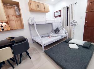 ein Wohnzimmer mit einem Etagenbett und einem Schreibtisch in der Unterkunft SNOW Studio Apartment - Near Clark International Airport in Mabalacat