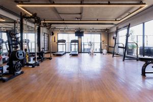 a gym with treadmills and machines in a room with wood floors at Way Tambaú #J2 - Triplo deluxe por Carpediem in Tambaú