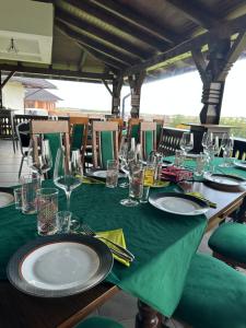 a table with plates and glasses on a green table cloth at Livada Bucovinei in Horodnic de Sus