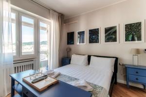 Un dormitorio con una cama y un escritorio y una ventana. en Turchese - by MyHomeInComo, en Como