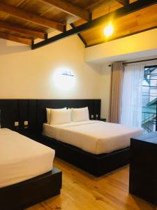 a bedroom with two beds and a window at R21 Nuwara Eliya in Nuwara Eliya