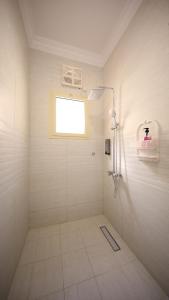 a white bathroom with a shower and a window at Stay easy Obhur - ستاي ايزي in Obhor +30 photos