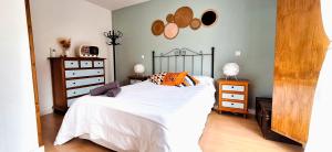 ein Schlafzimmer mit einem Bett mit weißen Laken und orangefarbenen Kissen in der Unterkunft Mirador de Bergosa VU-HUESCA-20-111 in Castiello de Jaca + 31 Fotos