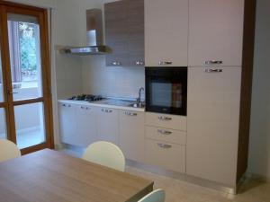 a kitchen with white cabinets and a table with chairs at DaPa Home in Selargius