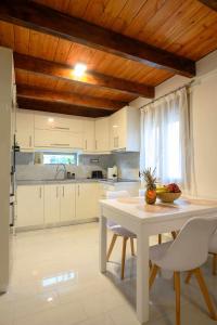a kitchen with a white table and white chairs at LIVAS Residence in Tympáki