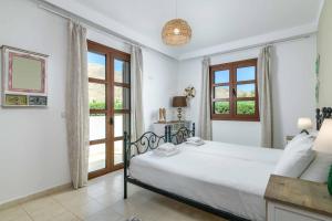 a white bedroom with a bed and a window at Lindos Topaz in Lindos +18 photos