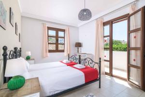 ein Schlafzimmer mit einem Bett mit einer rot-weißen Decke in der Unterkunft Lindos Ruby in Lindos + 11 Fotos