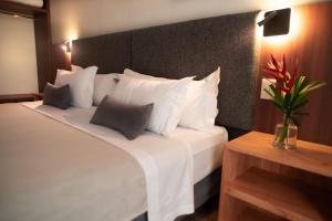 a bedroom with a large white bed with white pillows at Hotel Saint George in Puerto Iguazú