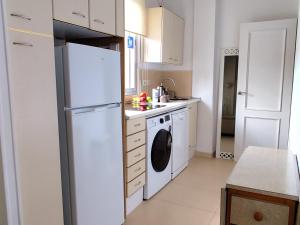 a kitchen with a white refrigerator and a dishwasher at VUT Skyline in Segovia