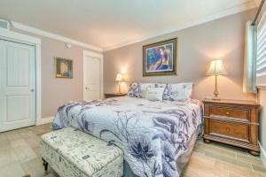 a bedroom with a bed with a blue and white bedspread at Beach House Condominiums B101 - Beachfront with Pool, WiFi, & Beach Service in Destin