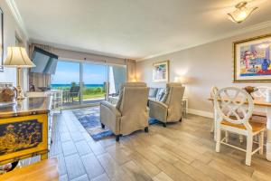 a living room with a table and chairs and a desk at Beach House Condominiums B101 - Beachfront with Pool, WiFi, & Beach Service in Destin