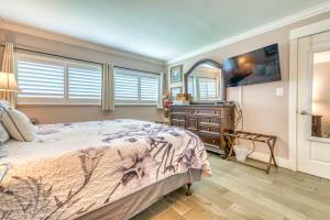 a bedroom with a bed and a dresser and a mirror at Beach House Condominiums B101 - Beachfront with Pool, WiFi, & Beach Service in Destin