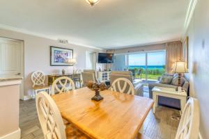 a dining room and living room with a wooden table and chairs at Beach House Condominiums B101 - Beachfront with Pool, WiFi, & Beach Service in Destin
