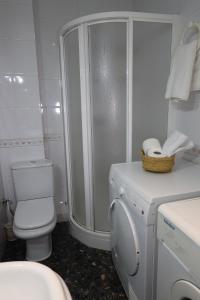 a white bathroom with a toilet and a shower at Antonia Medina Relax in Cogollos de Guadix
