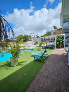 un patio con una silla azul y una piscina en Villa Raven`s Paradise (Lavender), en Willemstad