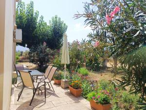 a patio with a table and chairs and a umbrella at Eirini- Ioanna in Sami