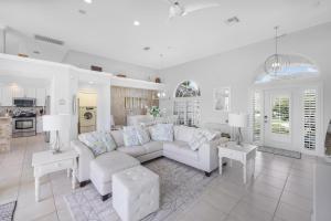 a living room with a white couch and a kitchen at W exposure waterfront home with pool and dock in Marco Island