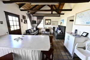 a kitchen and living room with a large white table at Agulhas Heights self-catering cottages BEST OCEAN VIEWS in Agulhas