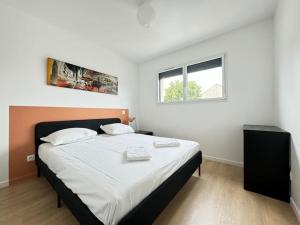 a bedroom with a large bed with white sheets and a window at Maison 8 couchages Parking Extérieur,Climatisation -Mesange in Aubière