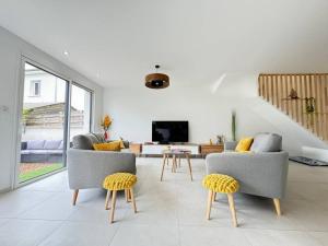 a living room with two chairs and a television at Maison 8 couchages Parking Extérieur,Climatisation -Mesange in Aubière