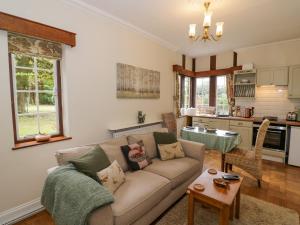a living room with a couch and a kitchen at Fox Cottage in Droitwich