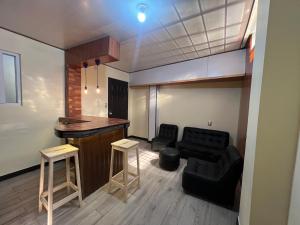 sala de estar con bar y sofá negro en C&M Exclusive Private Rooms, en Quetzaltenango