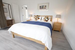 a bedroom with a large white bed and a mirror at Carrick Gate in Carrick