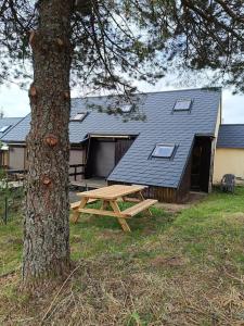 a picnic table next to a tree in front of a house at Charmant Chalet de montagne in Picherande